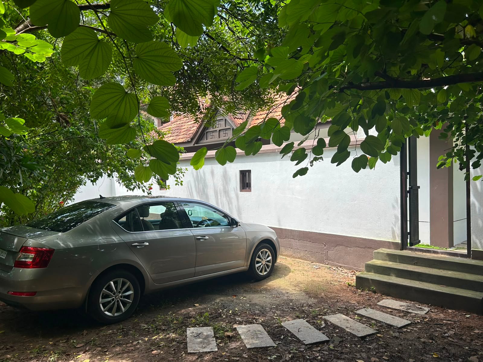 Shaded courtyard and parking area beside the homestay